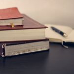 pen notebook and books on the table
