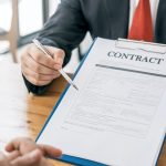 person holding contract and a pen