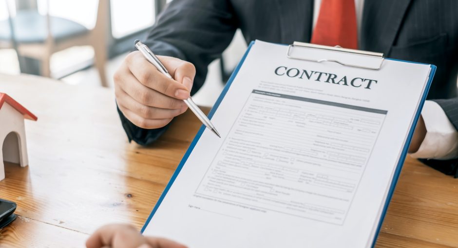 person holding contract and a pen