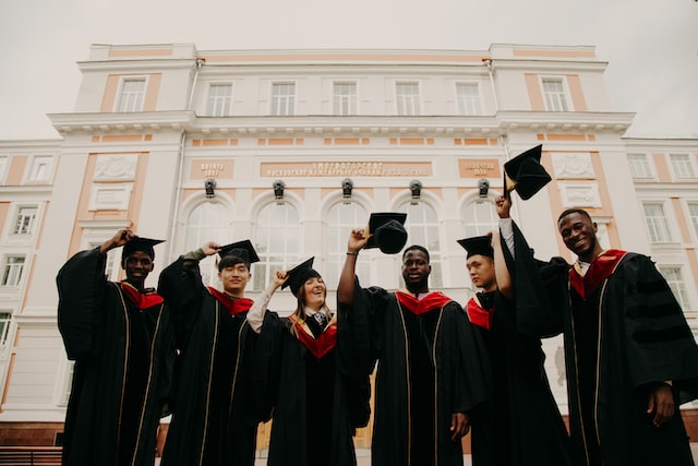 persons in black academic hats smiling